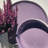 Eine Bowl und ein Teller in der Farbe Lavendel Blossom neben einem Topf Heide