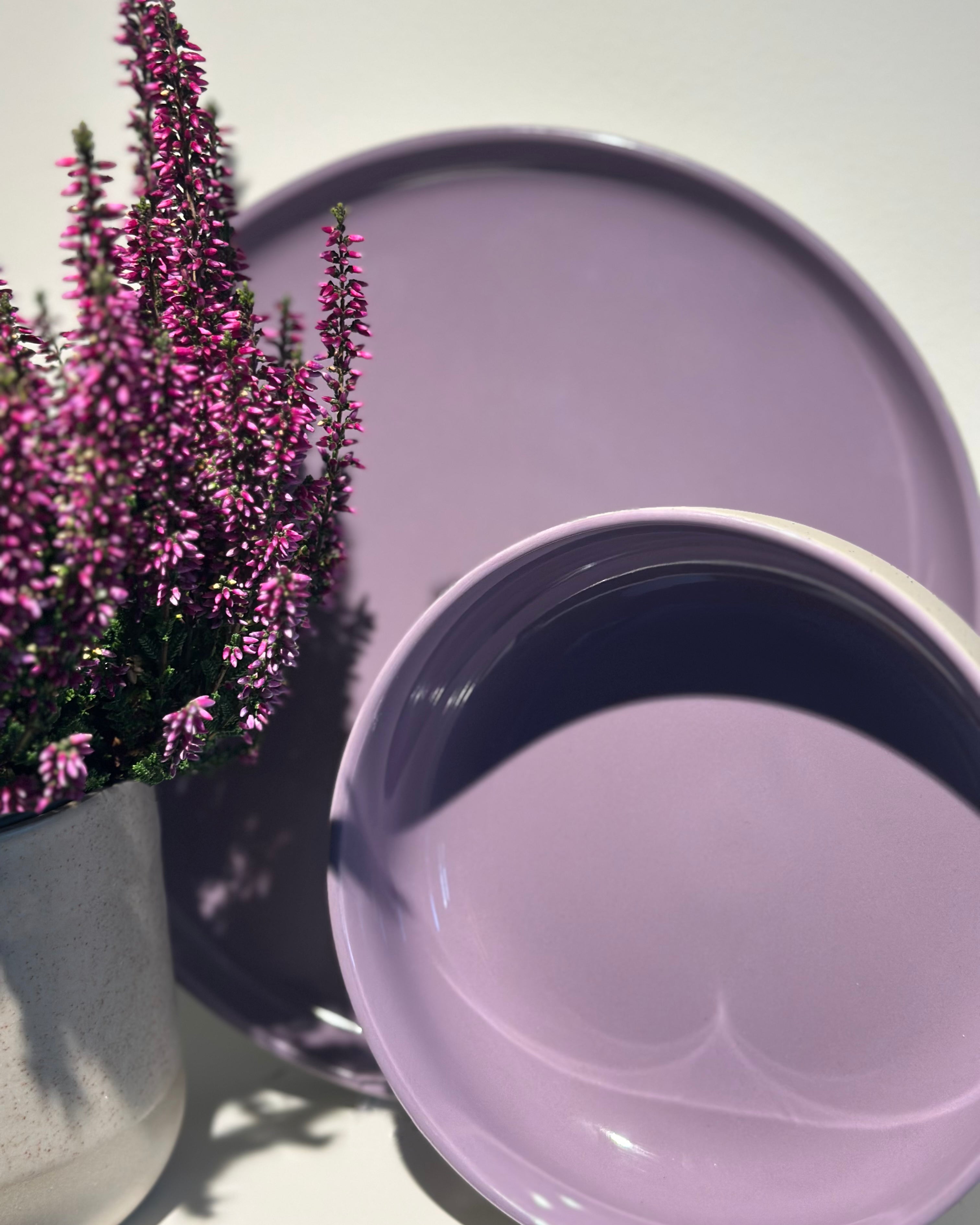 Eine Bowl und ein Teller in der Farbe Lavendel Blossom neben einem Topf Heide