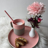 Teller und Becher aus recycelter Keramik mit Keksen und Blumen