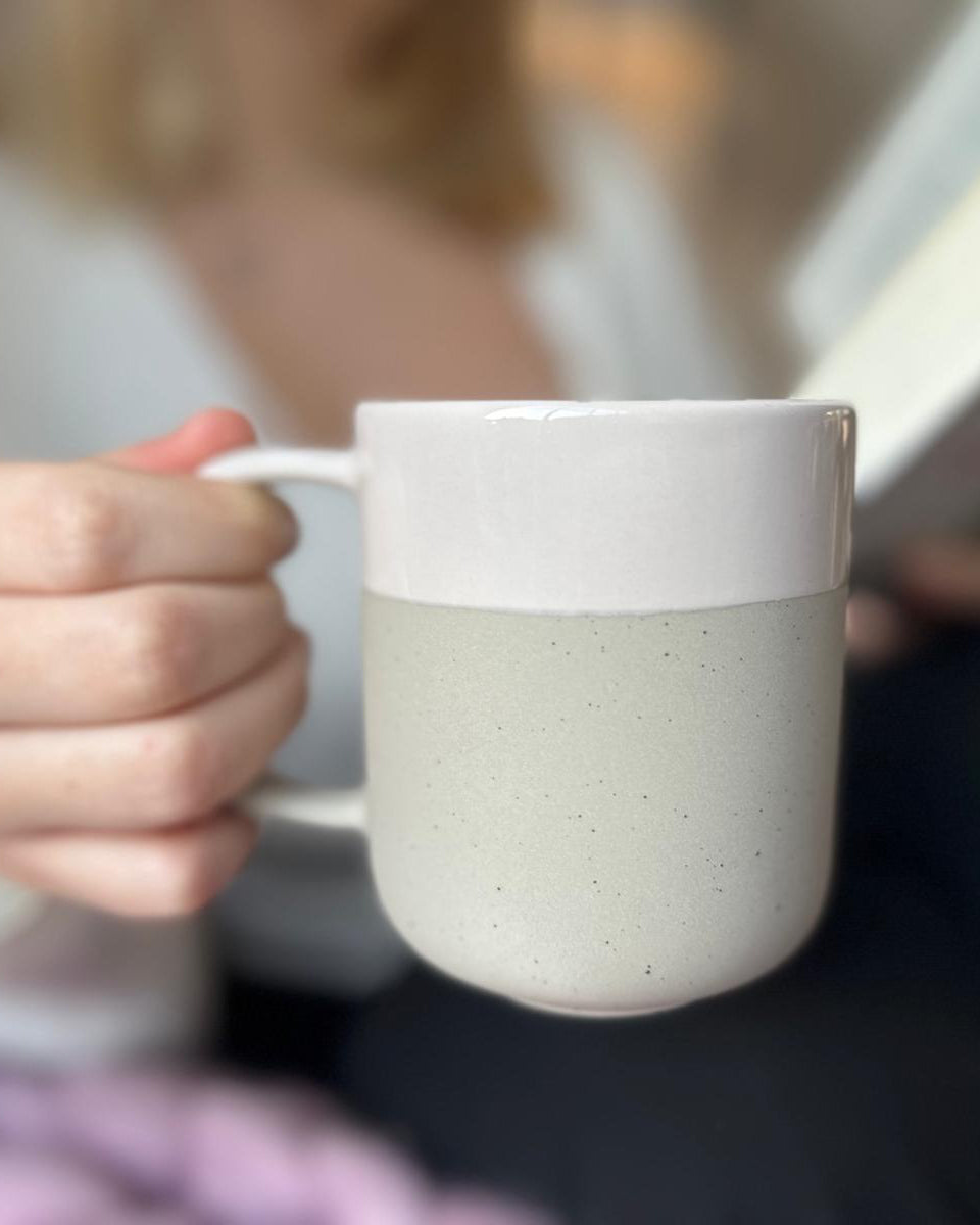Becher Nova Mei in der Farbe Soft Beige in der Hand gehalten