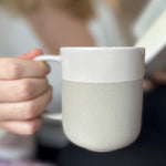 Becher Nova Mei in der Farbe Soft Beige in der Hand gehalten