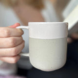 Becher Nova Mei in der Farbe Soft Beige in der Hand gehalten